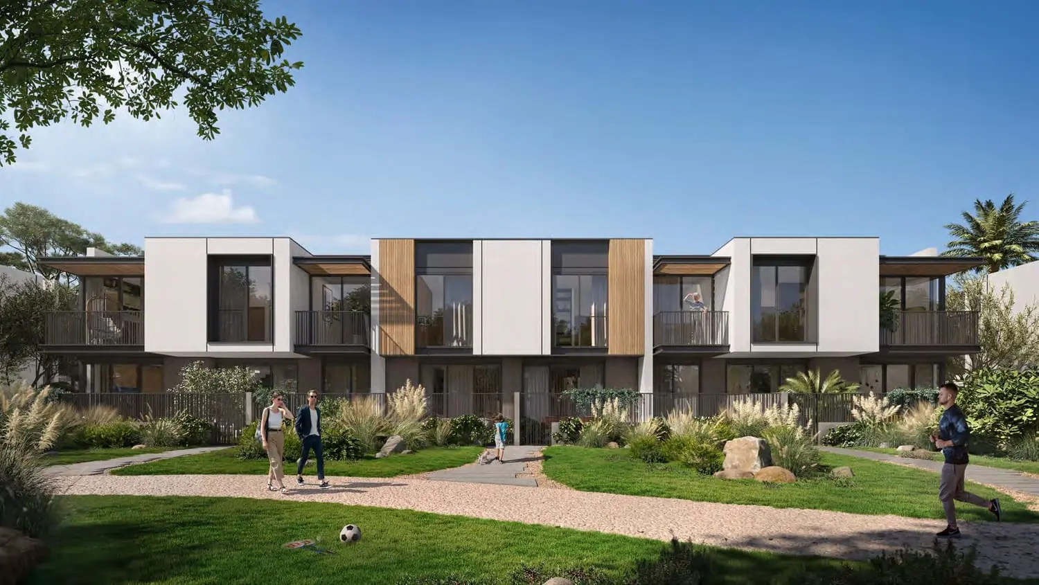 Greenwoods townhouses in Dubai Silicon Oasis facing a landscaped lawn and garden path.